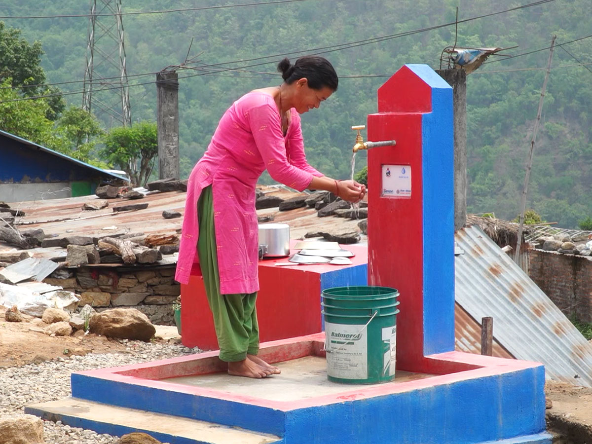 Woman using a Made Blue water point in Nepal